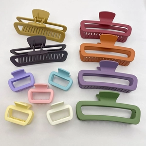 Flat lay of square matte rubber hair claws in 11 colors and two sizes on white background