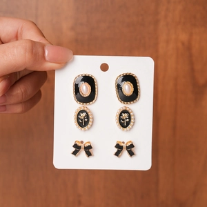 Macro view of vintage style earrings set with black enamel, pearls and gold finish
