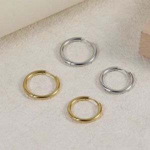 Detailed view of polished gold and silver stainless steel hoop earrings in two sizes