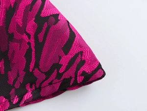 Detailed macro view of black and magenta floral jacquard fabric texture and weave