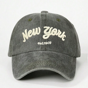 Detailed close-up of white 3D embroidery New York text on washed charcoal grey cotton cap