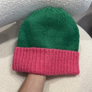 Detail of green and pink contrasting knit beanie showing soft chunky yarn texture