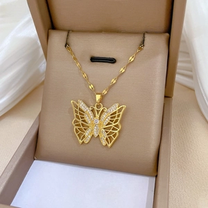 Detailed close-up of a gold filigree butterfly pendant with sparkling cubic zirconia inlay