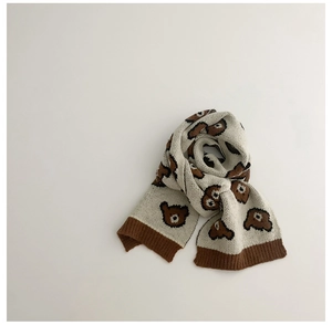 Detalle de bufanda de punto para niños crema con diseño de oso y bordes acanalados
