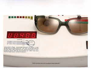 Detail view of green pilot sunglasses undergoing UV400 protection performance testing