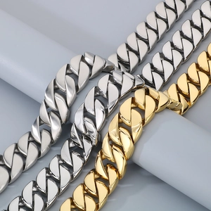 Close-up of 31mm polished gold and silver chunky Cuban link chains on display stand