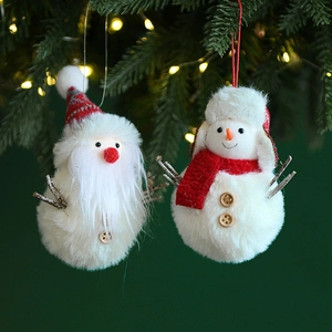 Christmas plush Santa and snowman ornaments hanging on a lighted pine tree branch