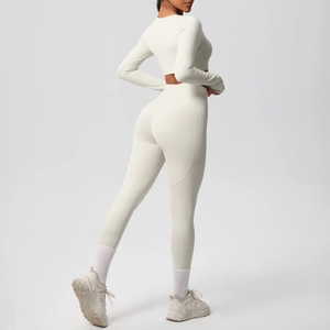 Detail view of cream-colored yoga set featuring high-waist leggings and cropped long sleeve