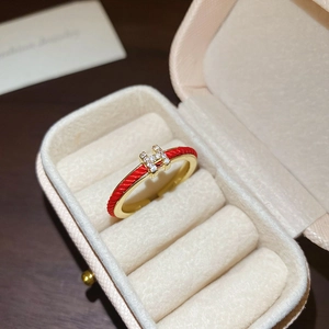 Close-up of golden red snake string ring with crystal H-letter design and red enamel finish