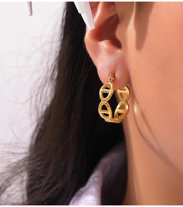 Close-up of 18k gold plated stainless steel oval link earring on a model ear