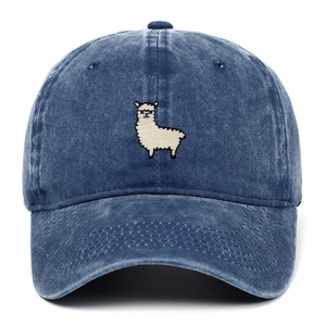 Detailed close-up of white sheep embroidery on washed blue denim baseball cap fabric