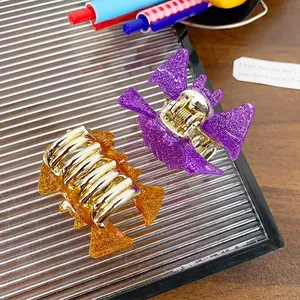 Halloween bat hair claws in purple and orange glitter acrylic on a glass tray