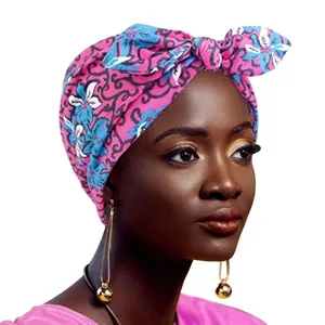 Detail of rose red African print wide headband with bow knot on a female model