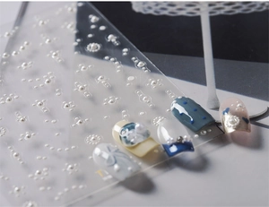 Detailed view of 3D pearl nail stickers with embossed patterns on manicured tips