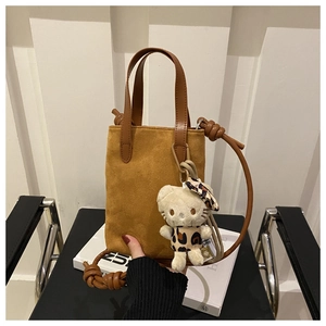 Close-up of suede crossbody bag with leopard print Hello Kitty charm and knot detail