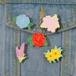 Set of 5 floral enamel pins featuring lily and rose designs on denim jacket