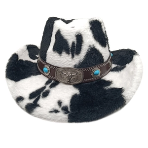 Close-up of cow print felt hat featuring vintage bull head metal buckle and turquoise beads