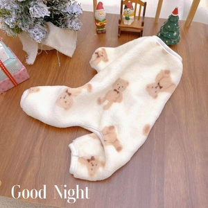 Fleece dog pajamas with bear pattern on wooden desk with festive holiday decor