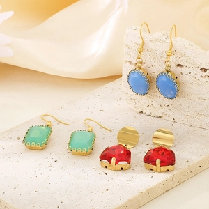 Three pairs of oval glass earrings in red, blue, and green with golden steel hooks