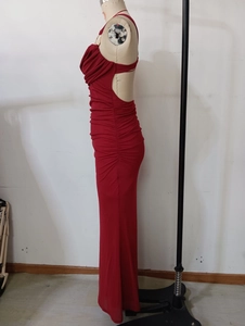 Detail of red ruched party dress featuring side pleats and elegant metal neck ring