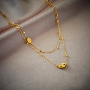 Double-layer gold plated chain necklace with blue eye pendant on grey silk background