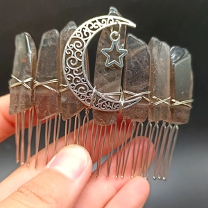 Close-up of handmade natural crystal hair comb with metallic star and moon details