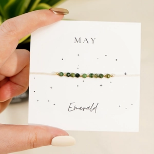 Handmade May birthstone emerald bead bracelet with gold accents on a display card