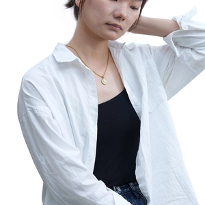 Gros plan détaillé du collier en acier inoxydable doré 18K avec pendentif lettre M ronde
