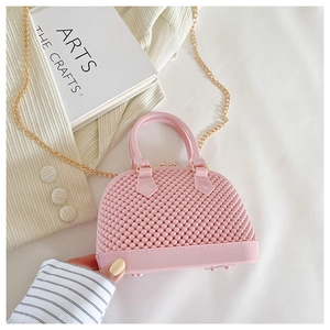 Top-down view of pink pearl beaded shell handbag with golden chain strap and woven texture