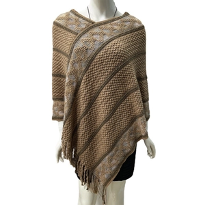 Close-up of brown and gray diamond knit poncho featuring a soft fringed tassel hem detail