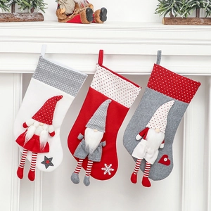 Three Nordic Christmas stockings with 3D faceless gnomes hanging on a white mantel