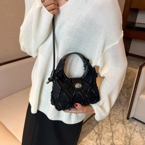 Black quilted canvas mini bag with frayed edge stitching and silver twist lock shown on model
