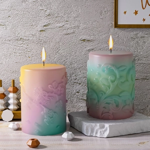Detailed view of 3D floral and leaf embossed relief patterns on gradient pillar candles