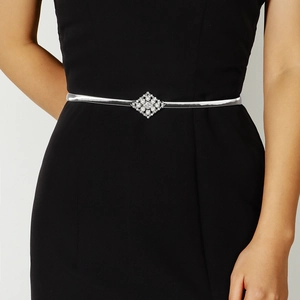 Close-up of silver elastic waist chain with diamond-encrusted pearl buckle on black dress