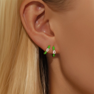 Close-up of neon green enamel drop earrings with sparkling teardrop-shaped zircons