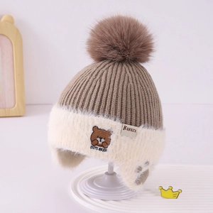Detail of winter knit hat with bear embroidery and soft plush ear flaps for kids