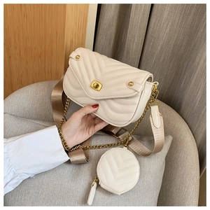 Detail view of cream crossbody bag with V-quilted faux leather and golden chain strap