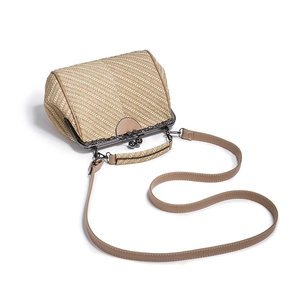 Detail of beige straw woven handbag with vintage metal frame clasp and brown faux leather strap