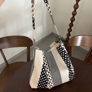 Dettaglio di una grande borsa tote in tela a pois bianchi e neri su un tavolo di legno