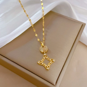 Macro detail of gold square starburst necklace with pave zirconia on silk background