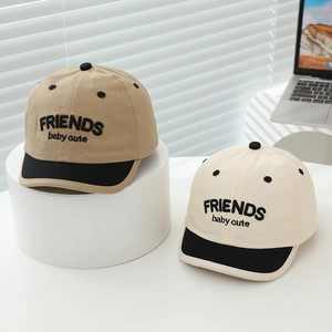 Detailed view of khaki and cream color-blocked baseball caps for infants and toddlers