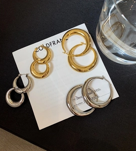 Polierte Gold- und Silber-Creolen in verschiedenen Größen auf einer Luxus-Displaykarte