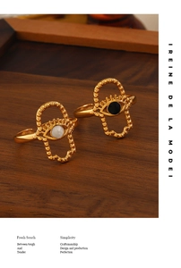 Détail de bagues œil maléfique plaquées or 18 carats sur bois de noyer et émail