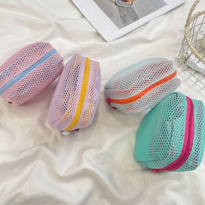 Macro view of mesh cosmetic bags with colorful zippers and breathable nylon texture