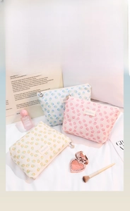 Detailed view of floral lace makeup bags with shell zippers and brand label
