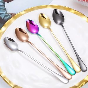 Long-handled stainless steel coffee spoons in five metallic colors on a white plate