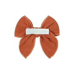 Solid rust orange cotton linen bow hair clip with fully wrapped safety ribbon clip