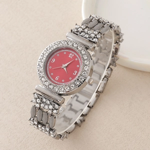 Détail d'une montre argentée avec strass, cadran rouge et bracelet aux motifs floraux
