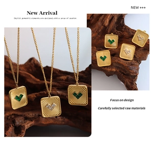 Detailed shot of gold square pendant necklaces and heart stud earrings set with green gems