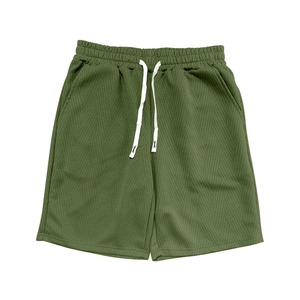 Détail du short en maille vert armée avec cordon blanc et texture jacquard à chevrons